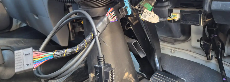 Vehicle OBD2 port with connected cable and GPS tracker wiring, representing OBD2 cables and GPS tracking solutions for cars and fleets in Australia