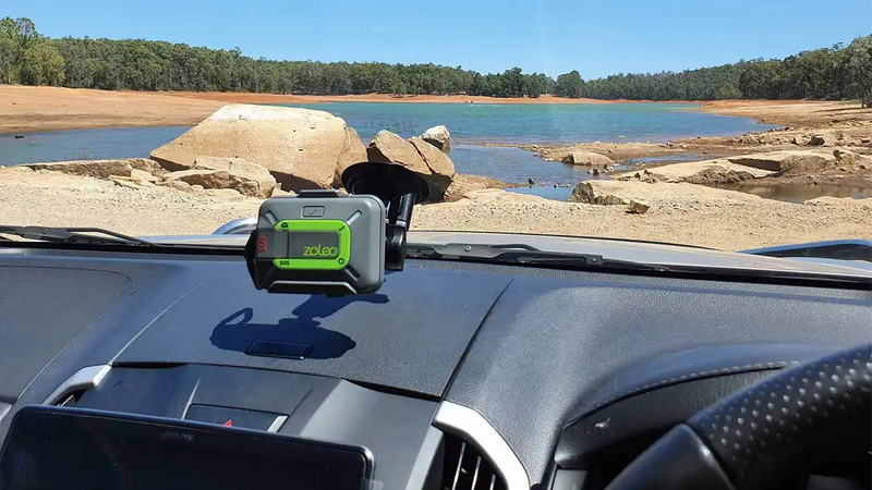 Zoleo satellite communicator mounted inside a vehicle with an outback lake view, providing reliable GPS location sharing, SOS alerts, and off-grid messaging in Australia.