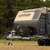 Off-road caravan parked in a grassy clearing, representing GPS tracking solutions for caravans, RVs, trailers, and off-grid travel.